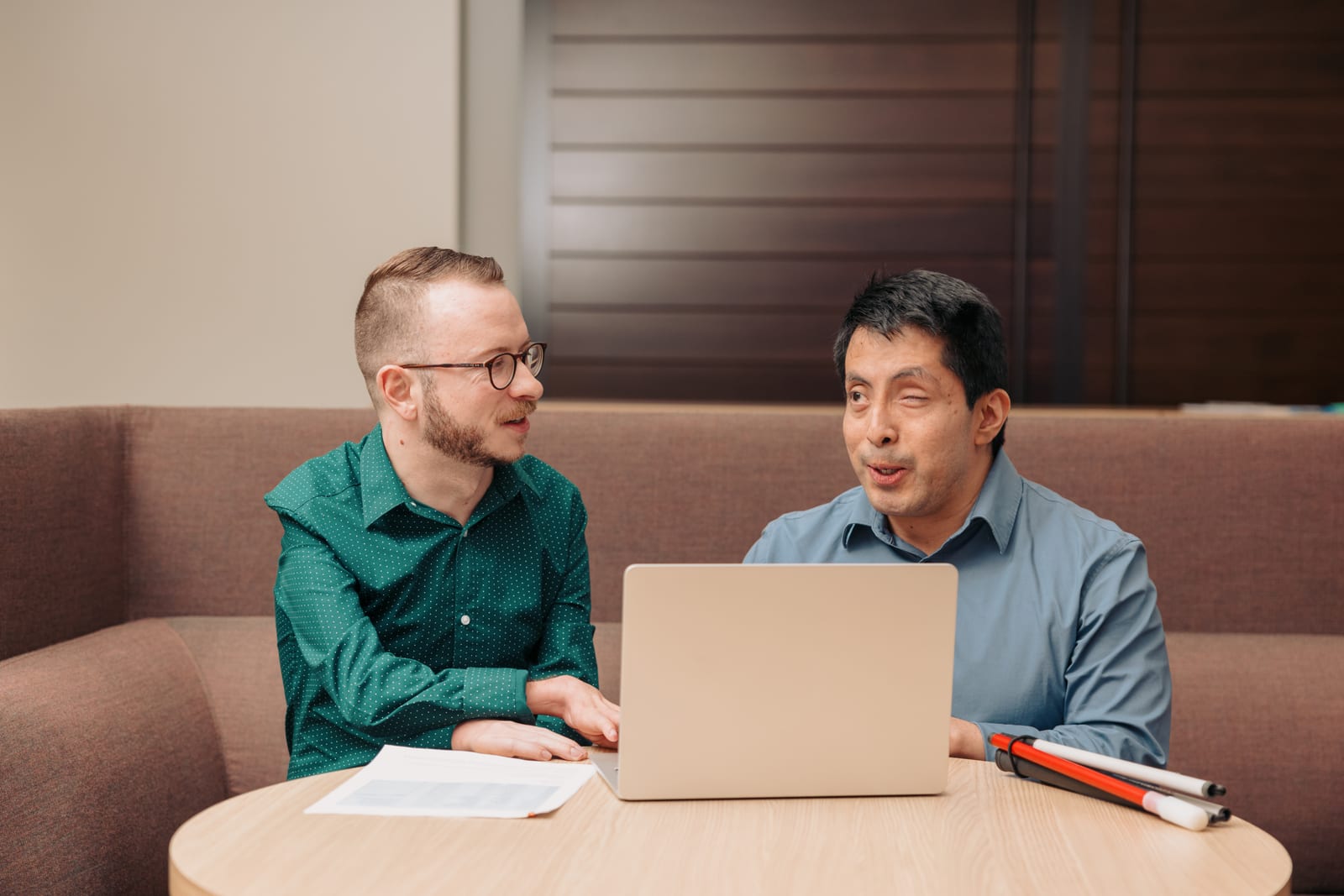 Two colleagues working on a computer together, representing the BuddyHub community platform.